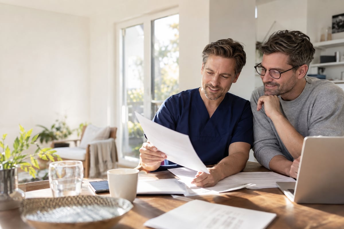 Arzt und Partner prüfen gemeinsam Unterlagen zu Hause